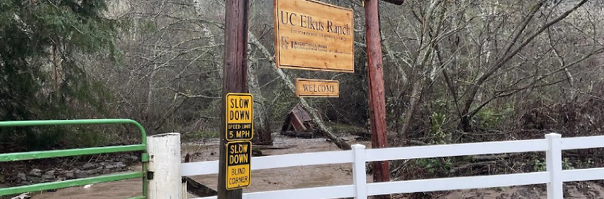 Muddy brown waters flow behind the sign welcoming visitors to Elkus Ranch.