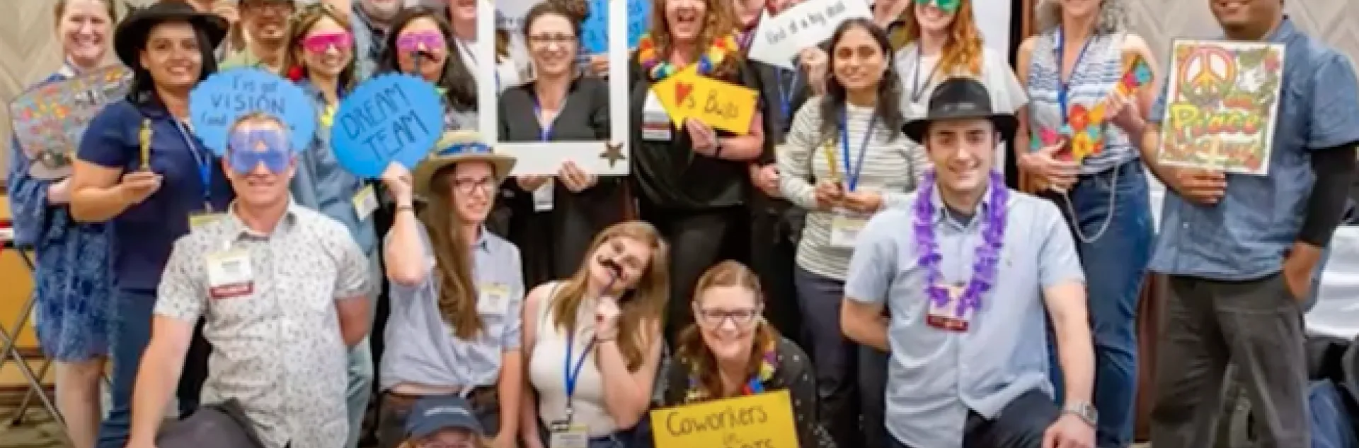 IPM team mugs for the camera wearing funny hats and holding props.