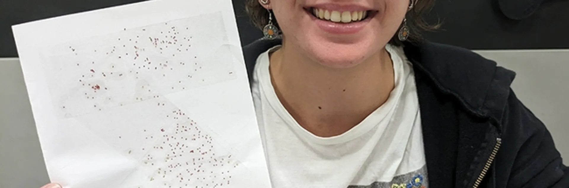 Hanna Briggs, a UC Davis transfer student, holds a sample card showing how glitter mimics insects. She is an intern in the laboratory of arachnologist Jason Bond, the Schlinger Endowed Chair, UC Davis Department of Entomology and Nematology, and associate dean, College of Agricultural and Environmental Sciences.
