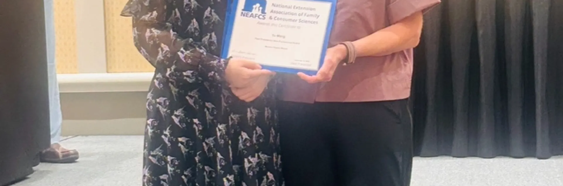 Yu Meng, receives the NEAFCS New Professional Award from Western Region President Dianne Christensen.