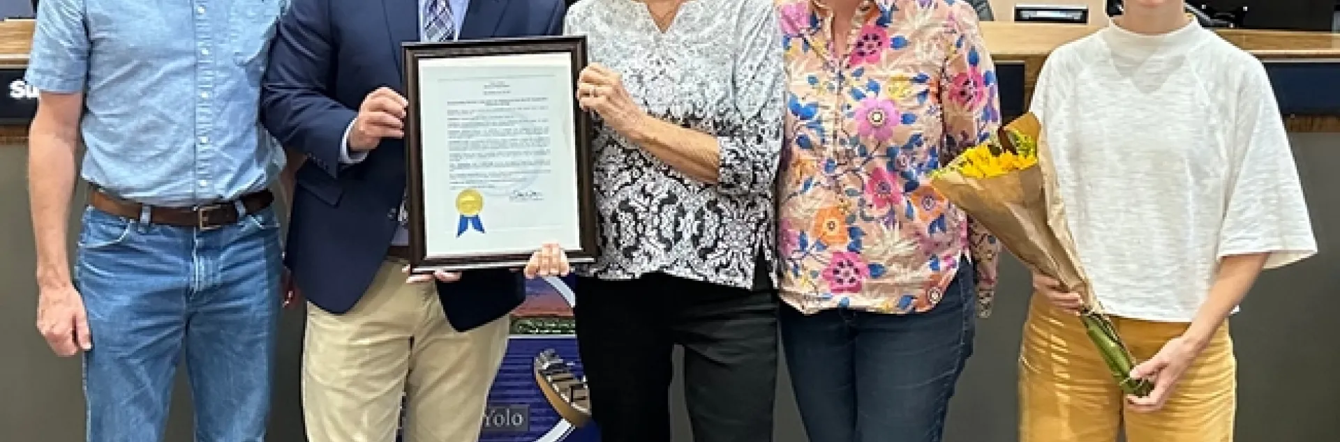 Rachael Long and Supervisor Angel Barajas hold up a plaque.