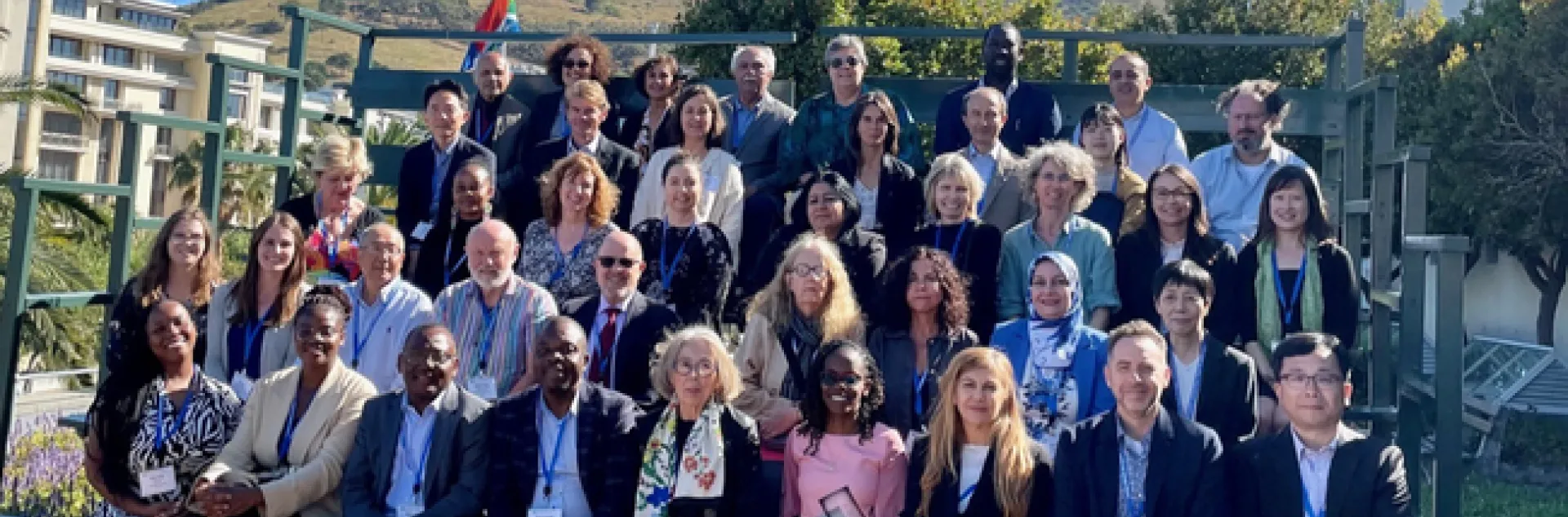 About 40 people sit in bleachers outdoors for a group photo.