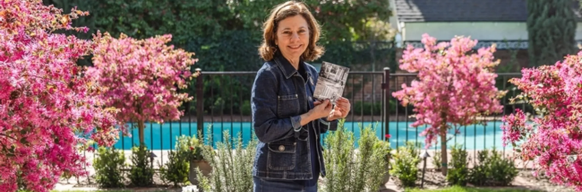 Barbara Vartan holds a photo of herself as a toddler enjoying the backyard at what is now the Clark/Kendrick home. (Photo: Sarah del Pozo)