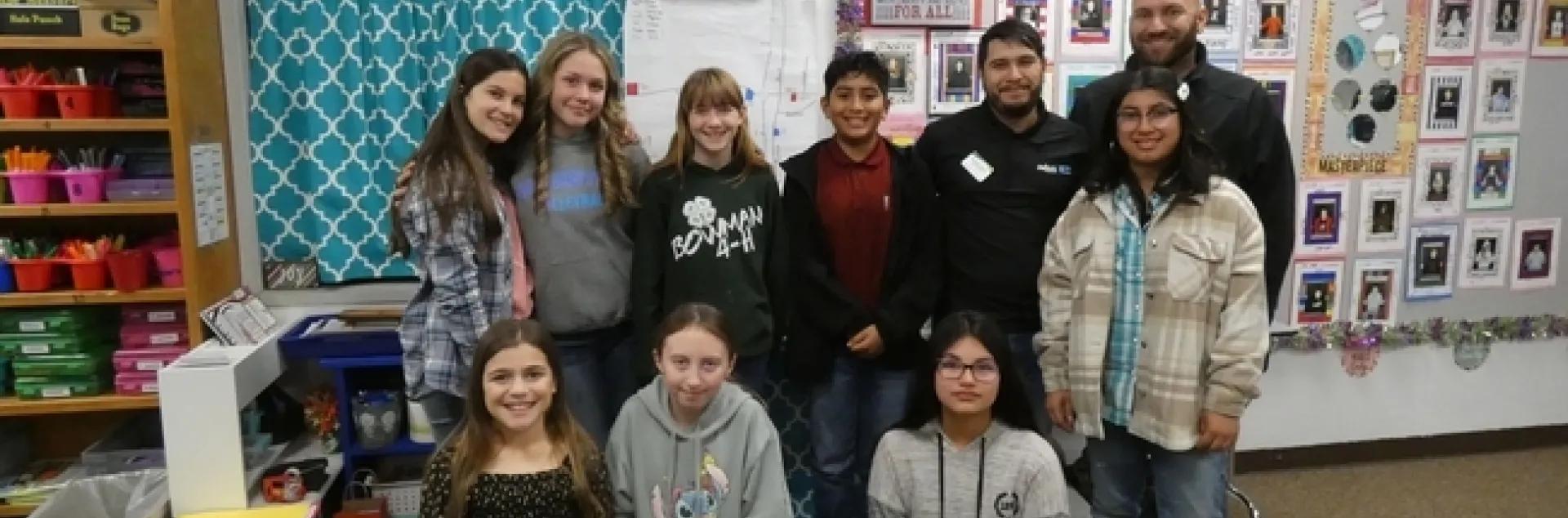 Ocho estudiantes de sexto grado daparecen en una fotografía en un salón de clases.