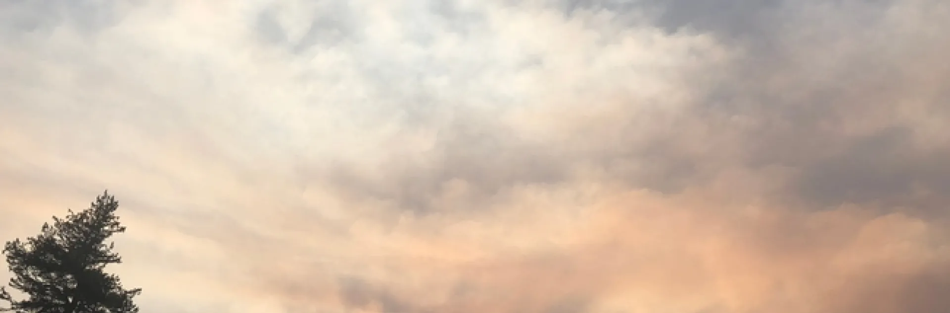 Smoke fills the air above forested mountains