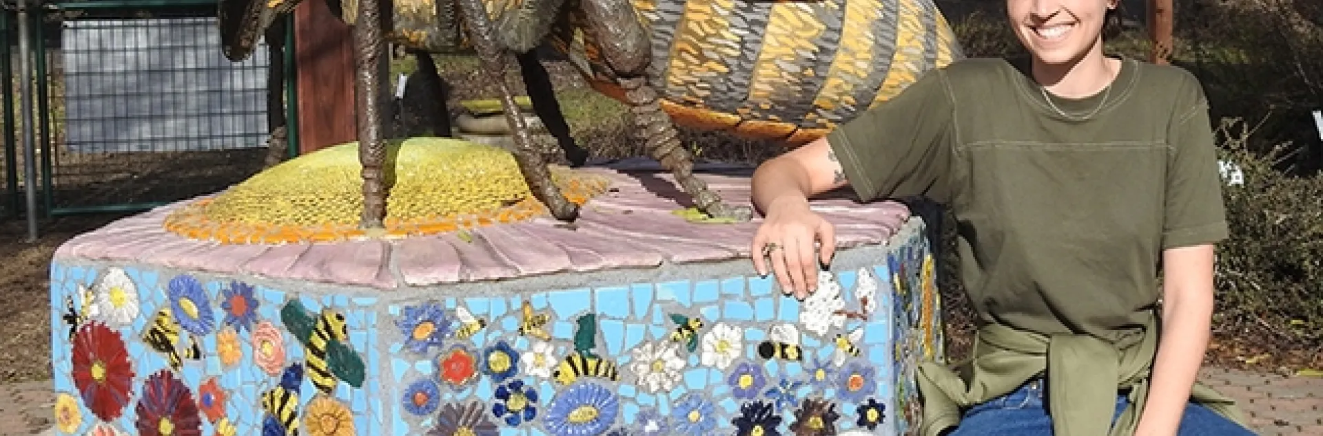 Michelle Monheit of Woodland stands by "Miss Bee Haven," sculpted by Donna Billick. Michelle has visited the garden since childhood when her mother was working on bee research. (Photo by Kathy Keatley Garvey)