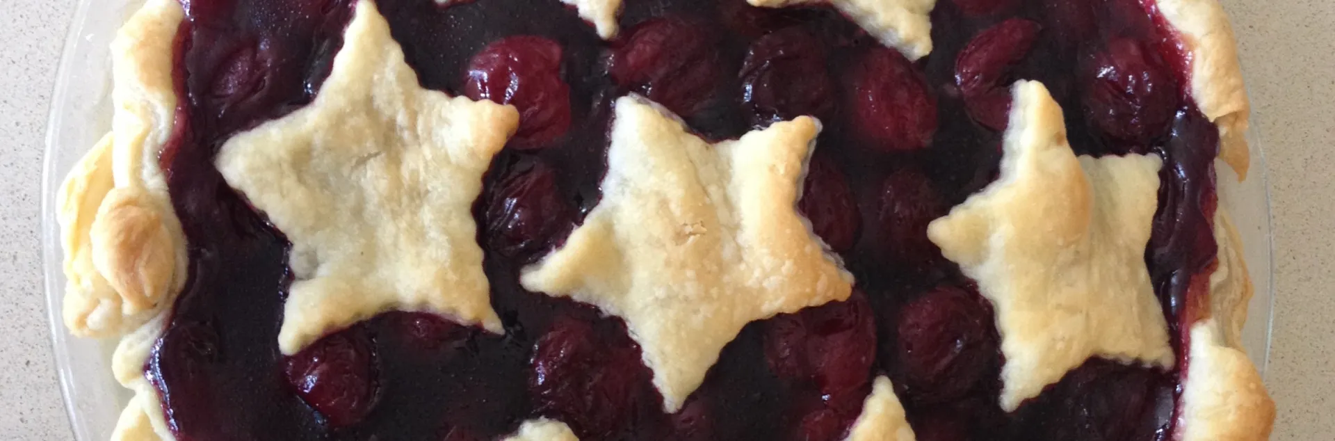 Photo of cherry pie with star pattern on top crust 