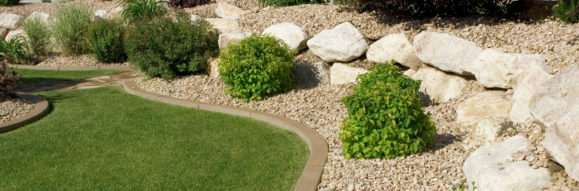 Drought tolerant landscape with rocks, grass and shrubs.
