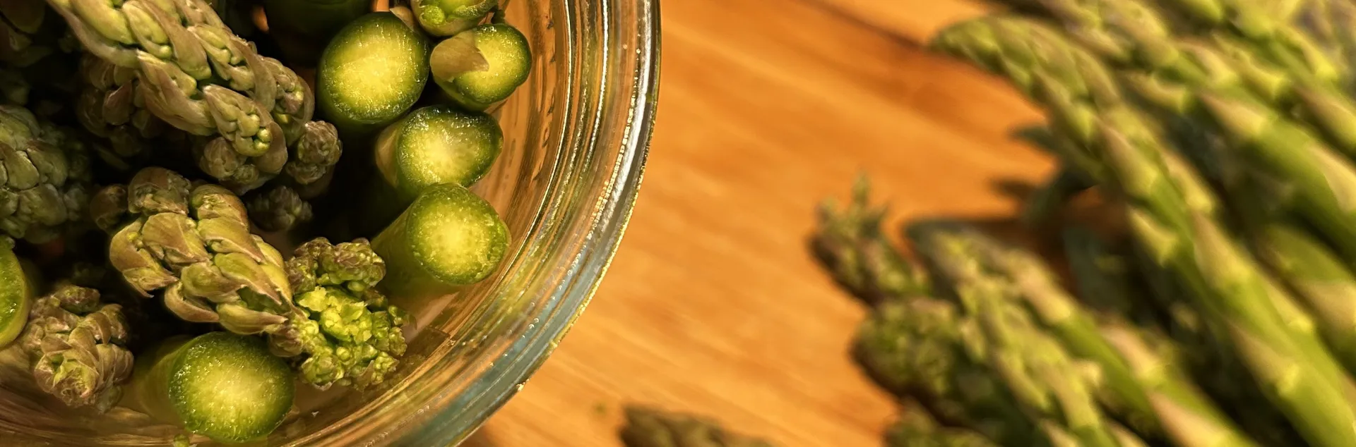 raw asparagus stuffed into a jar with flat end down