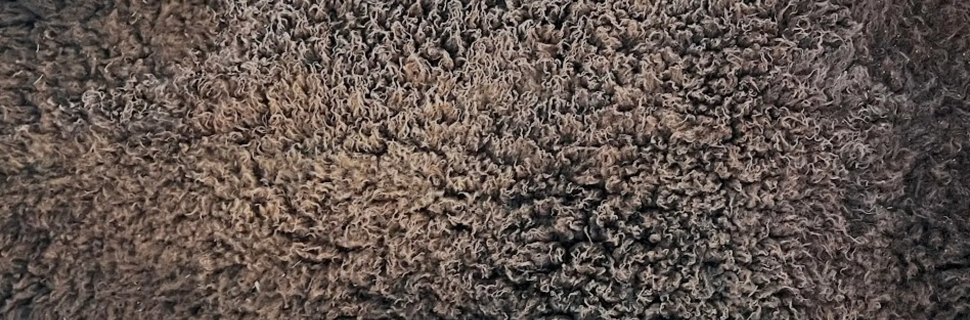 A chocolate brown fleece tanned sheep hide.
