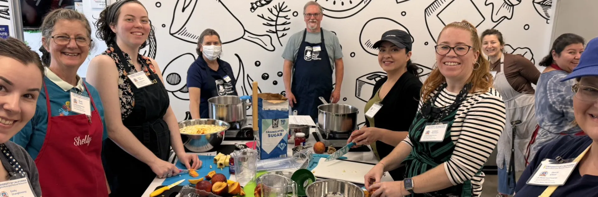 group of smiling people cooking with pots and pans