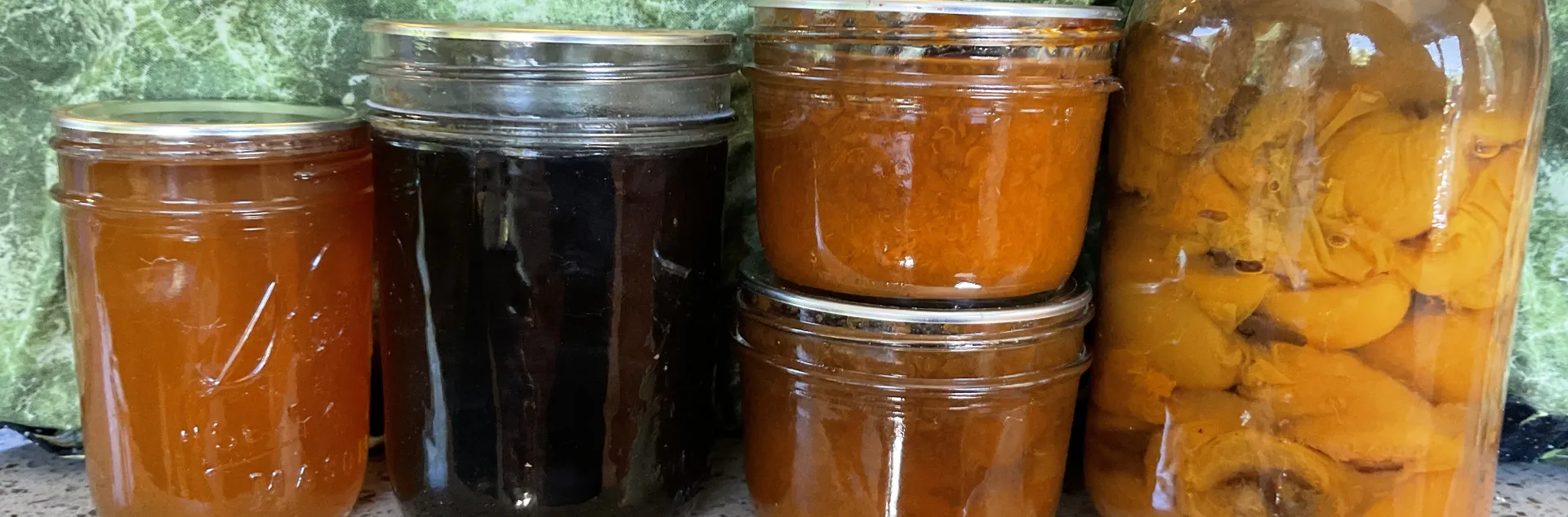 Lineup of preserved stone fruits in jars