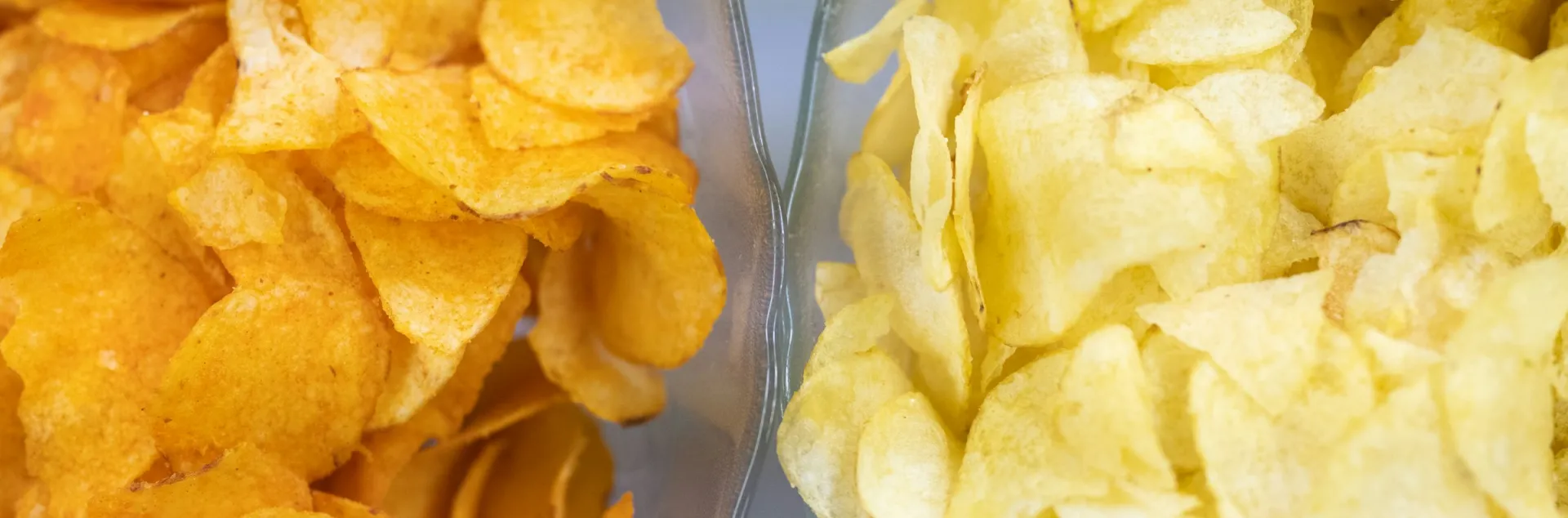 Two bowls of chips, one orange tinged and one plain yellow; photo by Melanie Weidmann via Unsplash