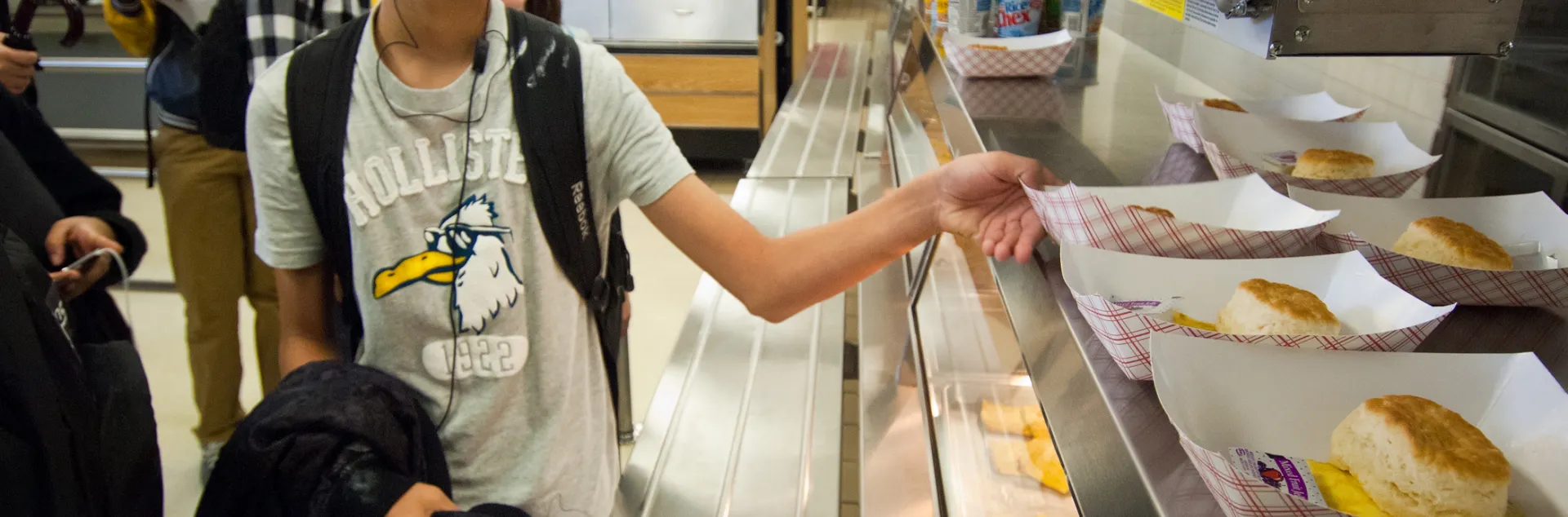 Image of a young adult grabbing breakfast from the school cafeteria.