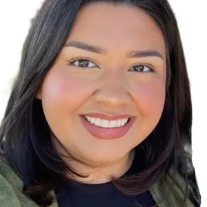 headshot of a woman with dark brown hair wearing a black top and green coat