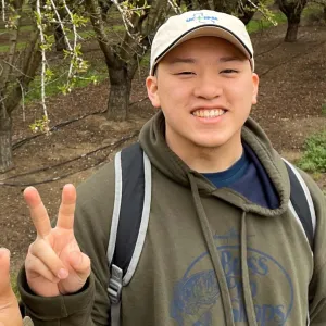 man with hat throwing a peace sign
