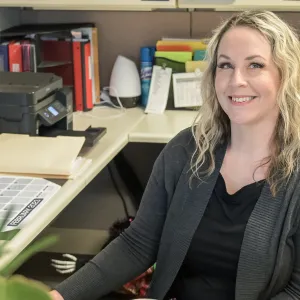 woman with blonde hair sitting at a desk