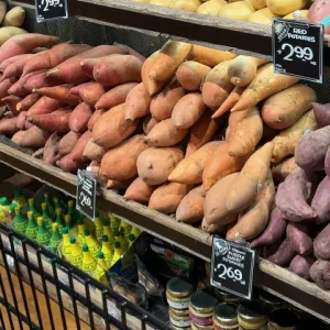 different colored varieties of sweet potatoes in a grocery store