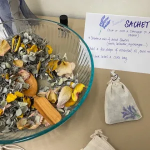 bowl of petal and other aromatic plant parts next to a sign about sachet making