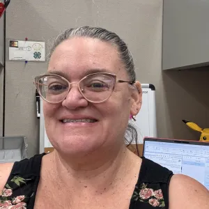 woman with her hair pulled back wearing glasses and a black patterned tank top
