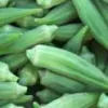 A close-up of several fresh green okra pods, elongated and tapered, arranged closely together.