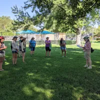 A crowd of people listening to a speaker in a park
